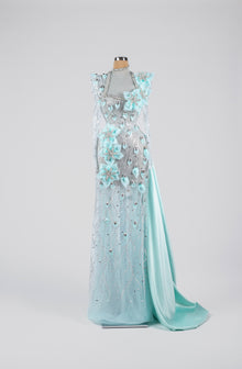 Sihëna Frosted Aurora Blossom — powder-blue high-neck long-sleeve gown with aqua organza florals and crystal beadwork on sheer tulle.