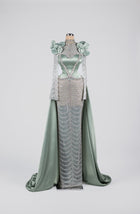 Sihëna Celestine Petal Crest — sage-green high-neck long-sleeve satin gown with floral shoulders, crystal beadwork and chain-drape skirt.