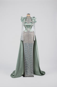 Sihëna Celestine Petal Crest — sage-green high-neck long-sleeve satin gown with floral shoulders, crystal beadwork and chain-drape skirt.