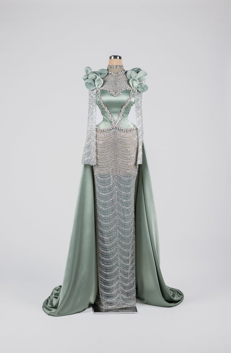 Sihëna Celestine Petal Crest — sage-green high-neck long-sleeve satin gown with floral shoulders, crystal beadwork and chain-drape skirt.