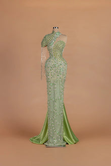 Sihëna Peacock Regalia — sage-green asymmetric sleeveless mermaid gown with crystal beading.